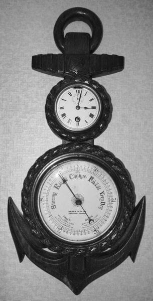 Clock with larger barometer below, set in wood in the shape of an anchor