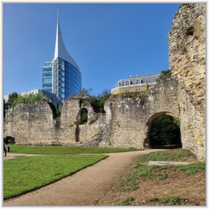 The historic stone ruins of Reading Abbey in Berkshire, with the modern, sail-shaped Blade building rising in the background.