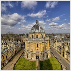 High-angle view of the Radcliffe Camera, a iconic circular domed library building in Oxford, surrounded by historic university architecture under a partly cloudy sky.
