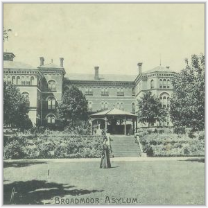 A historical view of Broadmoor Asylum showing its large Victorian building, terraced gardens with a gazebo, and a figure in Victorian dress standing on the lawn.