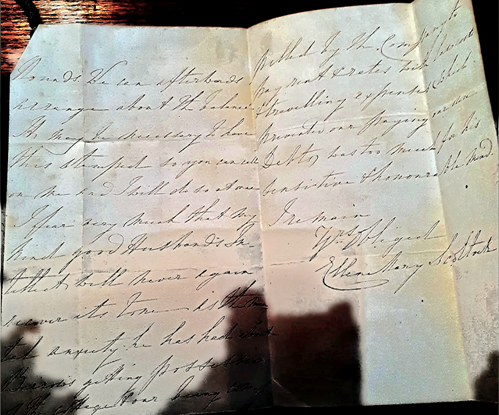 A photograph of a historical handwritten letter on aged cream-coloured paper, folded in half vertically and opened to show two pages. The letter is written in brown ink using 19th century cursive script. The paper shows fold creases and some age-related discolouration.
